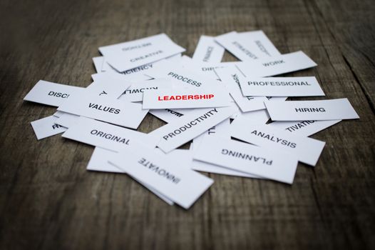 Paper strips with Leadership related words on wooden background