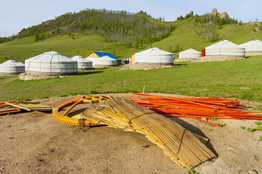 Components of a yurt in the foreground and in the background ready yurts