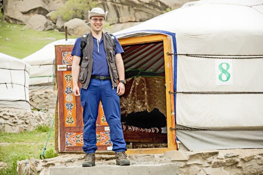 Man in outdoor clothes in front of the entrance of a Mongolian Yurt