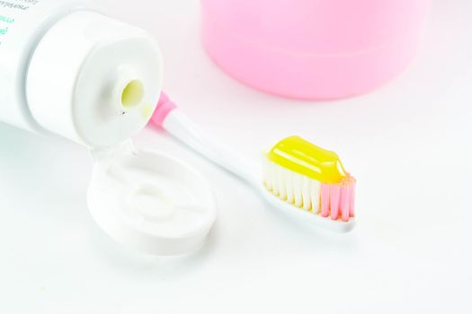 Toothbrush and toothpaste on white background