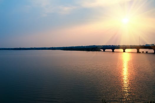 sunset over river with bridge