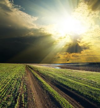 sun and clouds over road