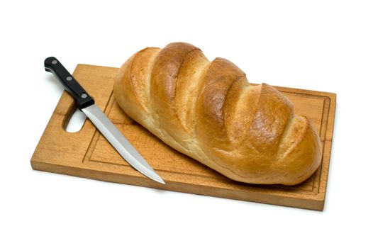 fresh natural bread with knife on breadboard