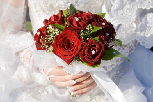 red roses bouquet in married woman's hand