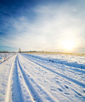 rural road under snow. winter sunset