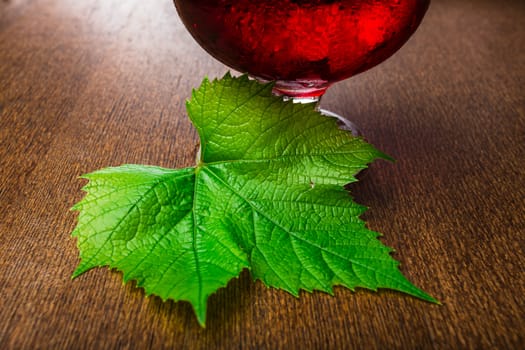 glass of wine with a vine on a table