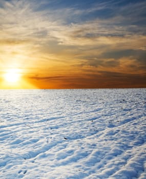 sunset over field under snow