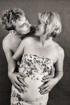 Loving happy couple, pregnant woman with her husband, black and white, looking at each other