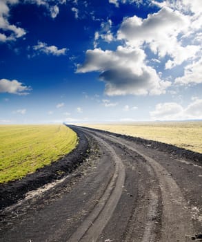 road to hazy horizon under cloudy sky