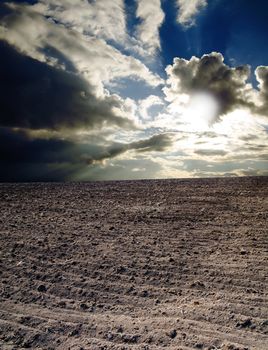 ploughed field under dramatic sky