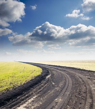 road to hazy horizon under cloudy sky