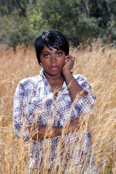 Close-up of a lovely young woman standing in tall grass.