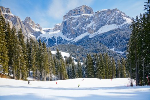 Skiers going down the slope at Sella Ronda ski route in Italy