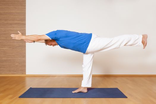 An image of a man doing yoga exercises - Virabhadrasana