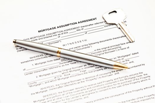 Mortgage assumption agreement with a pen for signature and a key
