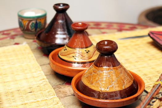 Different ceramic tajines with food on the table
