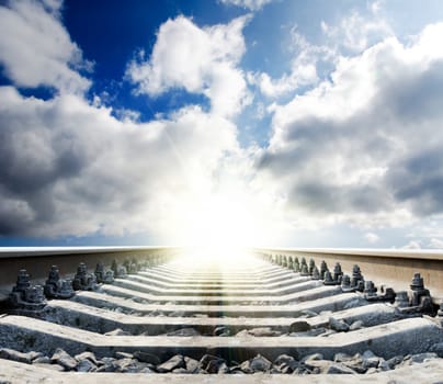 railway to sun under cloudy sky