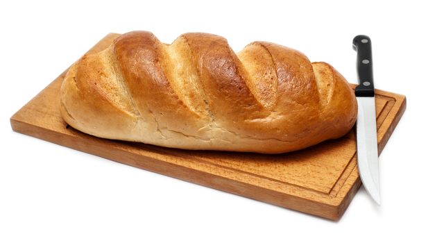 fresh bread with knife on breadboard