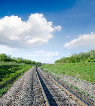 railway goes to horizon in green landscape