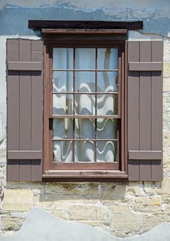 window with brown shutters in medieval european village