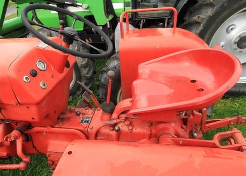 Close up of red antique tractor seat and wheel