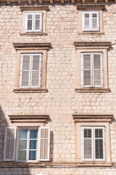 Framed ancient windows with shutters in a row.