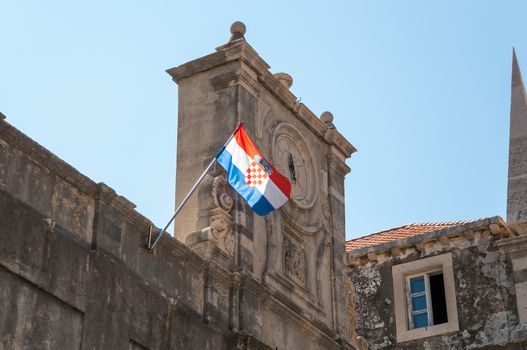 Old clock on a tower with croatian flag.