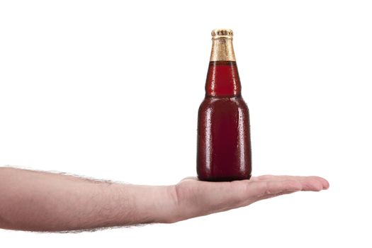 A bottle of beer in the palm of a hand.