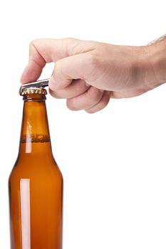 A hand opening a bottle of beer.