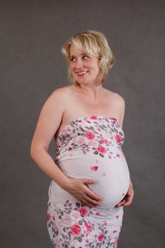 beautiful smiling pregnant woman tenderly holding her tummy