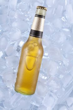 A bottle of blonde beer on ice.