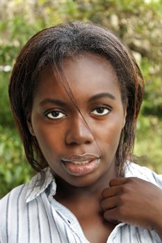 A close-up of a lovely young black woman outdoors.