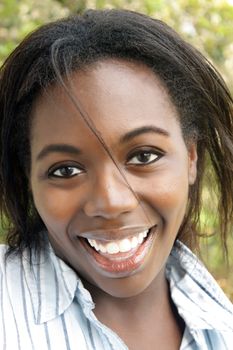 A close-up of a lovely young black woman outdoors.