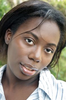 A close-up of a lovely young black woman outdoors.