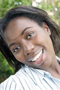 A close-up of a lovely young black woman outdoors.