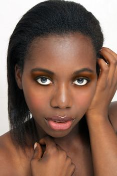 A close-up of a lovely, glamorous young black woman with bare shoulders.