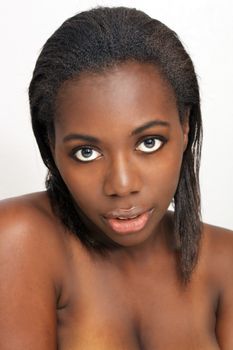 A close-up of a lovely young black woman with bare shoulders.