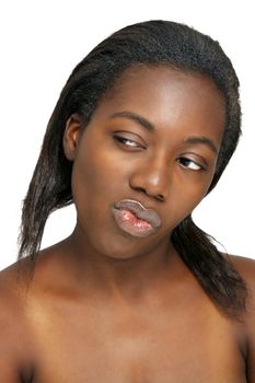 A close-up of a lovely young black woman with bare shoulders, looking toward frame left with a sly facial expression.