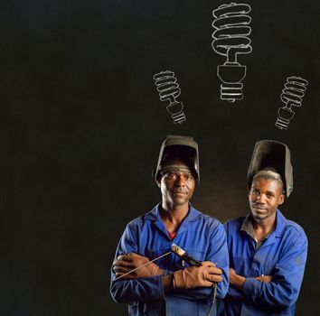 African or American black men industrial workers with chalk energy saving lightbulbs on blackboard background
