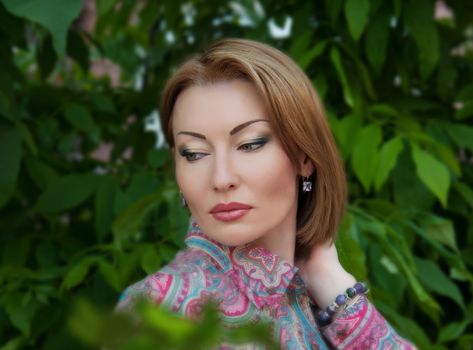 beautiful young woman on a background of leaves in summer