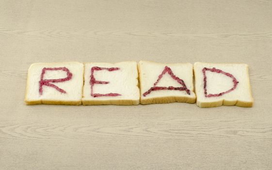 jam alphabet on sliced bread on wood background