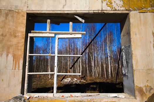 broken window in a wall of the collapsed house