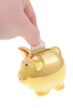 hand dropping money into a golden piggybank isolated on white