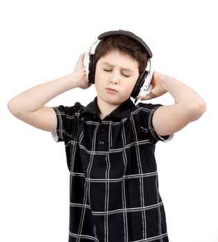 Portrait of a happy young boy listening to music on headphones against white background 
