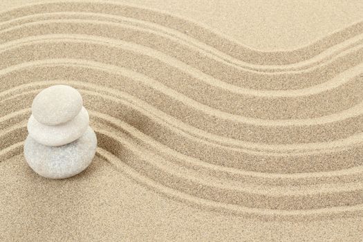 Balance of three zen stones in sand 