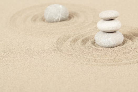 Balance of three zen stones in sand 
