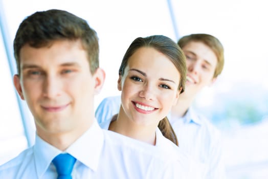 portrait of a young business woman standing in line with colleagues, concept of teamwork