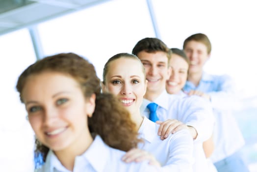 portrait of a young business woman standing in line with colleagues, concept of teamwork