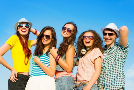 group of young people wearing sunglasses and hats hugging and standing in a row, spending time with friends