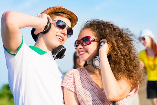 young couple standing on the road, having fun with friends